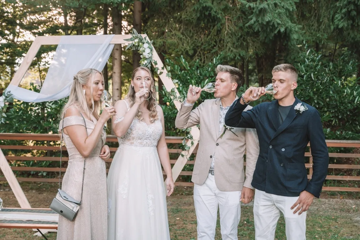 Poročna fotografija mladoporočencev; ujet pristen trenutek z naravno svetlobo in umirjeno kompozicijo v dokumentarnem slogu.