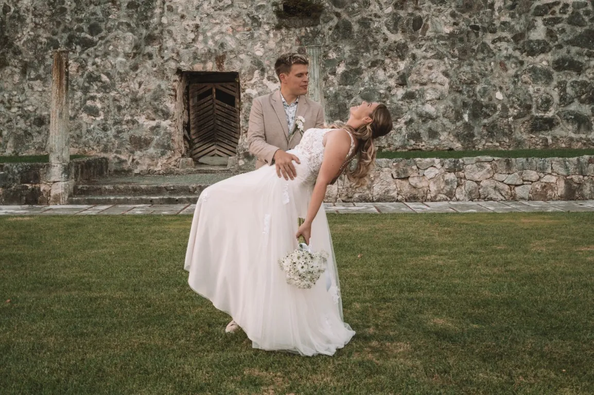 Poročna fotografija mladoporočencev; ujet pristen trenutek z naravno svetlobo in umirjeno kompozicijo v dokumentarnem slogu.